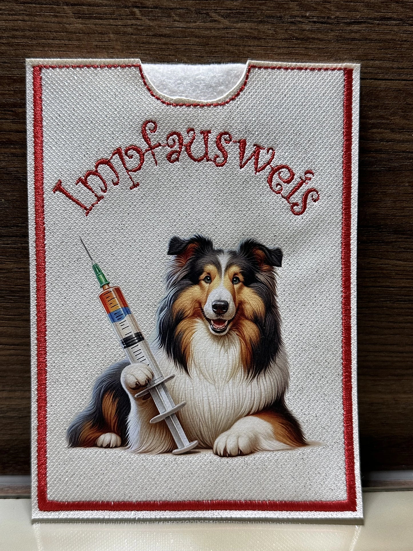 Handgemachte Impfpasshülle 12,5 × 17 cm aus weißem Glitzer-Kunstleder mit roter Naht und Collie Langhaar Motiv mit Spritze – passend für EU-Heimtierausweis