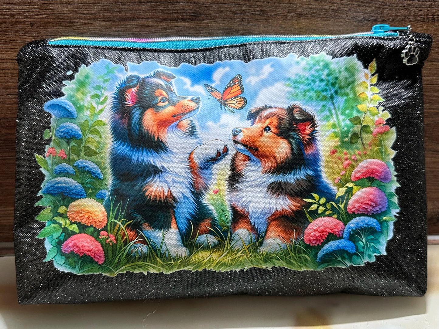 Kosmetiktasche Sheltie mit Schmetterling und Blumenmotiv auf schwarzem Glitzer-Kunstleder