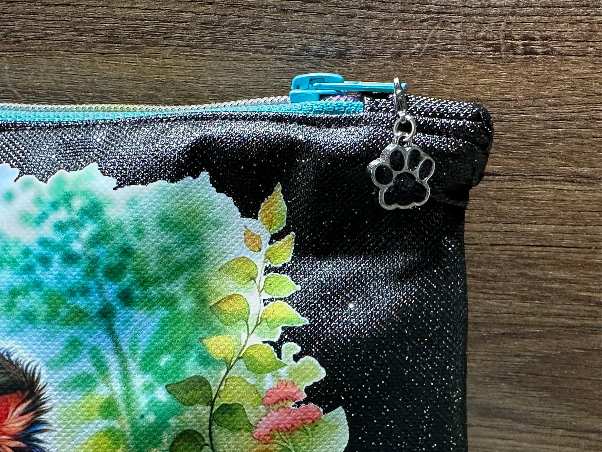 Detailaufnahme Reißverschluss mit silbernem Pfoten-Anhänger der Kosmetiktasche